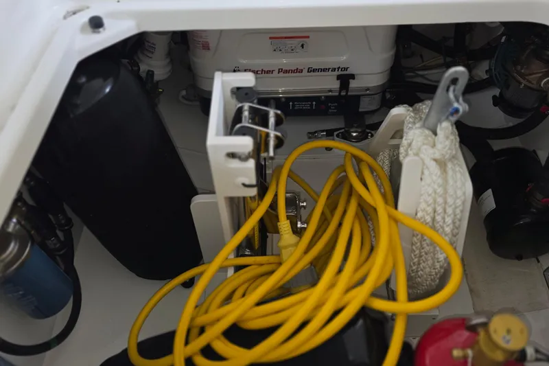 Slide: The Image of 2024 Pursuit DC 326 Dual Console engine compartment with generator and yellow power cables. - 30