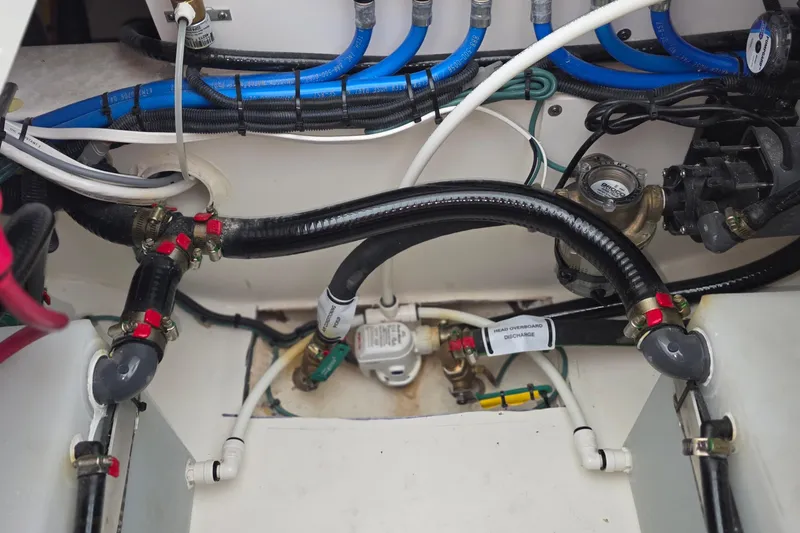 Slide: The Image of 2024 Pursuit DC 326 Dual Console boat plumbing system with hoses and valves. - 31