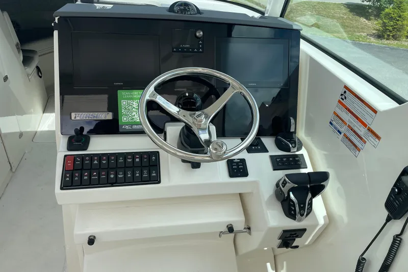 Slide: The Image of 2024 Pursuit DC 326 Dual Console helm with steering wheel, controls, and digital displays. - 9