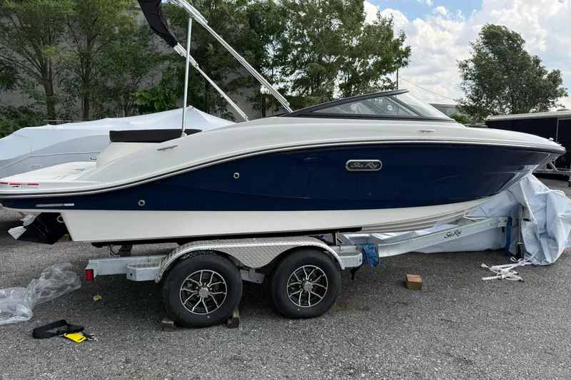 Slide: The Image of 2025 Sea Ray SPX 190 boat on trailer, parked outdoors. - 2