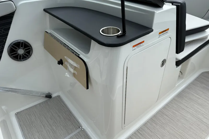 Slide: The Image of 2025 Sea Ray SPX 190 boat interior with storage compartment and cup holder. - 9