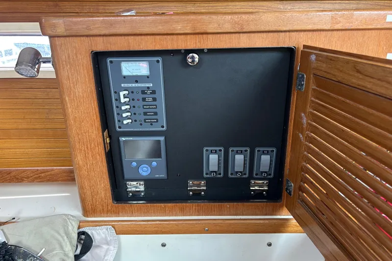 Slide: The Image of Electrical panel inside 1998 Catalina 36 MkII sailboat, featuring switches and controls. - 12