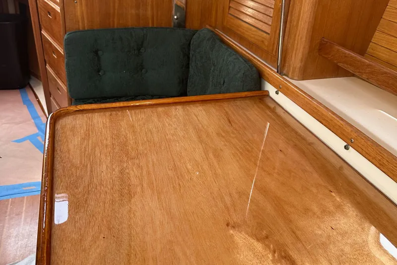 Slide: The Image of Interior of 1998 Catalina 36 MkII sailboat with polished wooden table and green cushioned seating. - 24