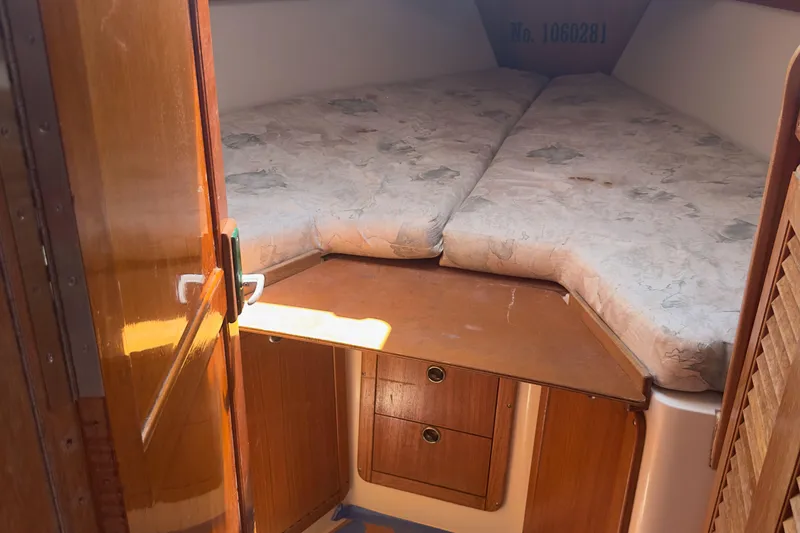 Slide: The Image of 1998 Catalina 36 MkII cabin interior with wooden storage and cushioned bed. - 4