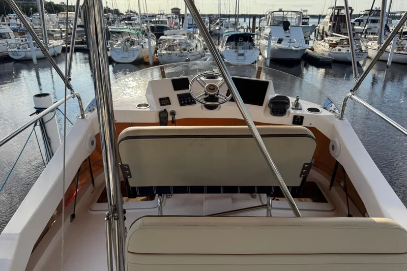 Slide: The Image of 2024 Ranger Tugs R31CB boat helm with marina view, showcasing steering and controls. - 11