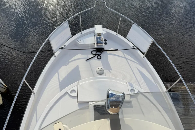 Slide: The Image of 2024 Ranger Tugs R31CB boat deck with railing, docked on calm water. - 13