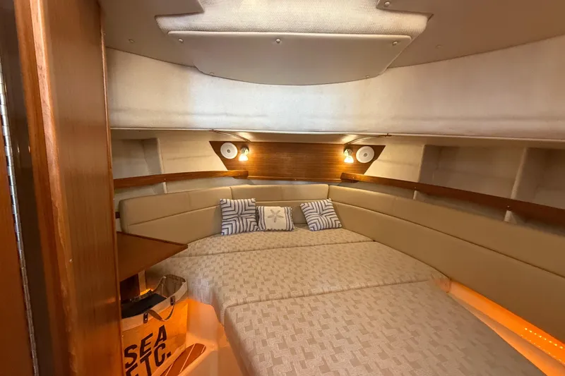 Slide: The Image of 2024 Ranger Tugs R31CB cabin interior with cozy bed and ambient lighting. - 23