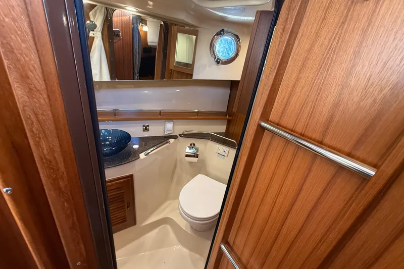 Slide: The Image of 2024 Ranger Tugs R31CB bathroom with wooden cabinetry and modern fixtures. - 25