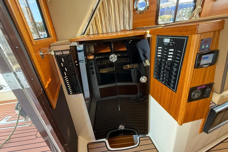 Slide: The Image of 2024 Ranger Tugs R31CB interior with control panels and wood finish. - 27