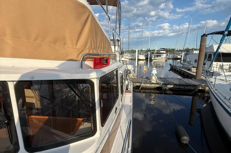 Slide: The Image of 2024 Ranger Tugs R31CB docked at marina under blue sky. - 4