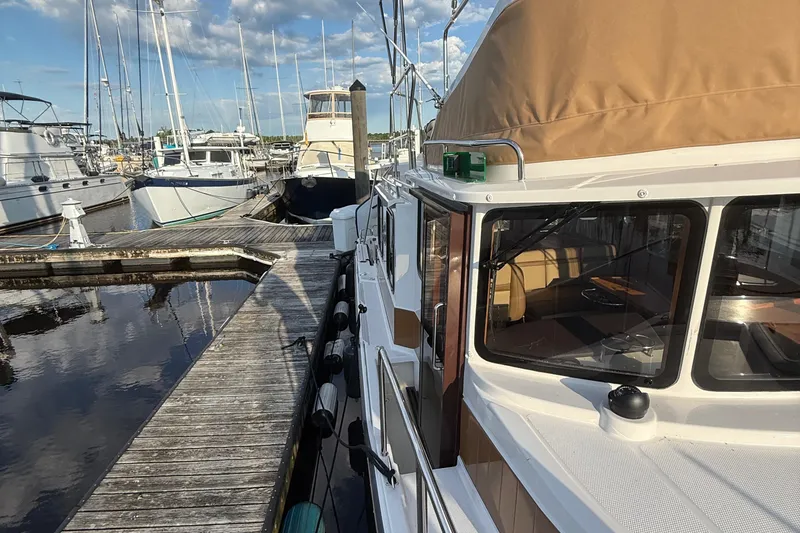 Slide: The Image of 2024 Ranger Tugs R31CB docked at marina, surrounded by other boats. - 5