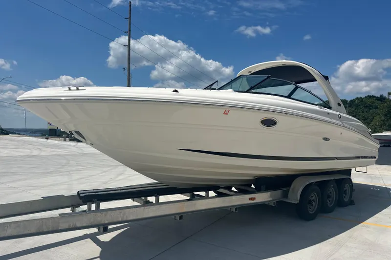 Slide: The Image of 2005 Sea Ray 290 SLX boat on trailer under clear blue sky. - 3