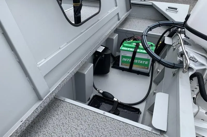 Slide: The Image of 2026 SeaArk Shadow 18 Center Console boat interior with battery compartment and wiring. - 9