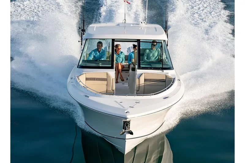 Slide: The Image of 2019 Pursuit DC 325 Dual Console boat cruising on water with passengers. - 95