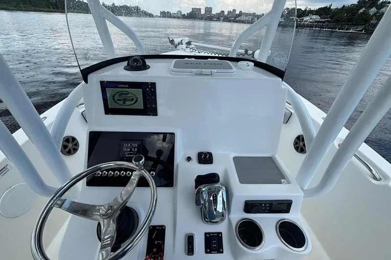 Slide: The Image of 2020 Sea Pro 219 Center Console boat dashboard with steering wheel and navigation equipment. - 13