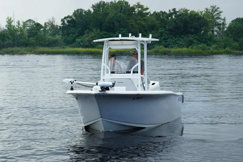 Slide: The Image of 2020 Sea Pro 219 Center Console boat on calm water with lush green shoreline. - 8