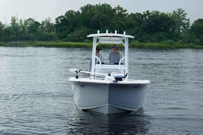 Slide: The Image of 2020 Sea Pro 219 Center Console boat on calm water, surrounded by lush greenery. - 9