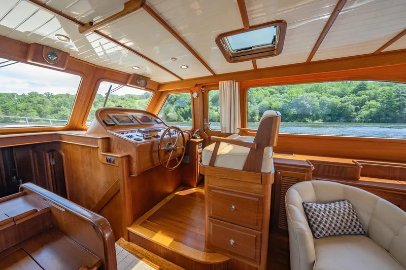 Slide: The Image of Luxurious 2007 Vicem 65 yacht interior with wooden helm, plush seating, and scenic water view. - 16
