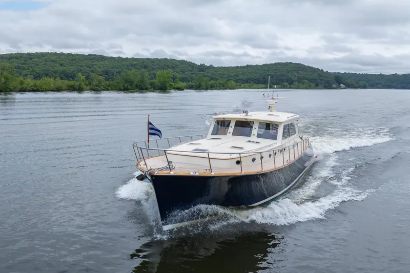 Slide: The Image of 2007 Vicem 65 yacht cruising on a scenic river with lush green hills. - 3