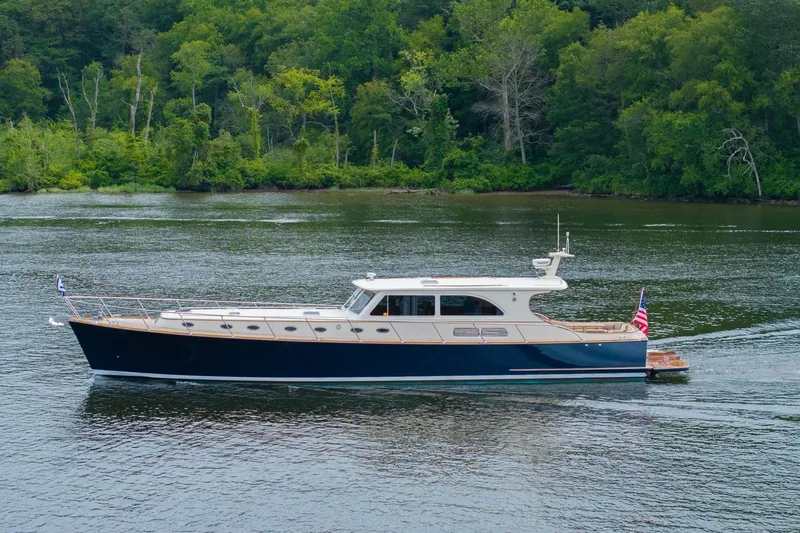 Slide: The Image of 2007 Vicem 65 yacht cruising on a serene river with lush green forest backdrop. - 4