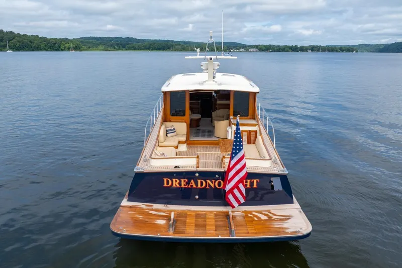 Slide: The Image of 2007 Vicem 65 yacht on calm water, featuring elegant wooden deck and American flag. - 5