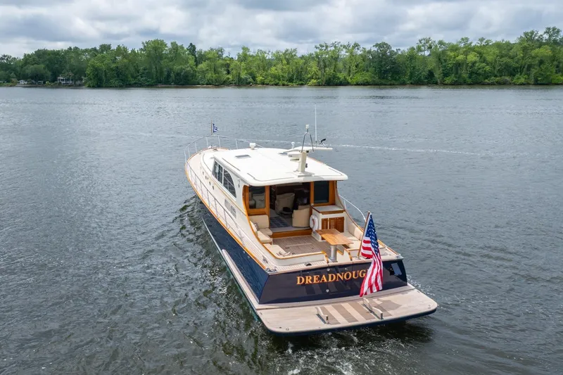 Slide: The Image of 2007 Vicem 65 yacht cruising on a serene lake with lush green shoreline. - 6