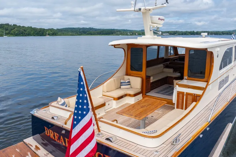 Slide: The Image of 2007 Vicem 65 yacht with American flag, featuring elegant wood and spacious seating. - 7