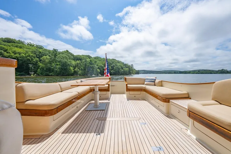 Slide: The Image of Luxurious 2007 Vicem 65 yacht deck with elegant seating, overlooking serene waters and lush greenery. - 8