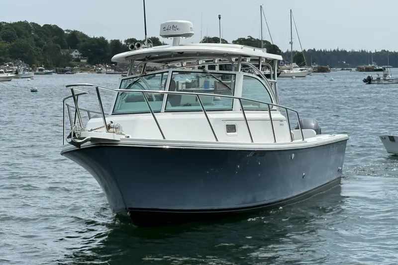 The Image of 2015 Parker 2510 XLD Walkaround boat on calm water, surrounded by other vessels. - 0