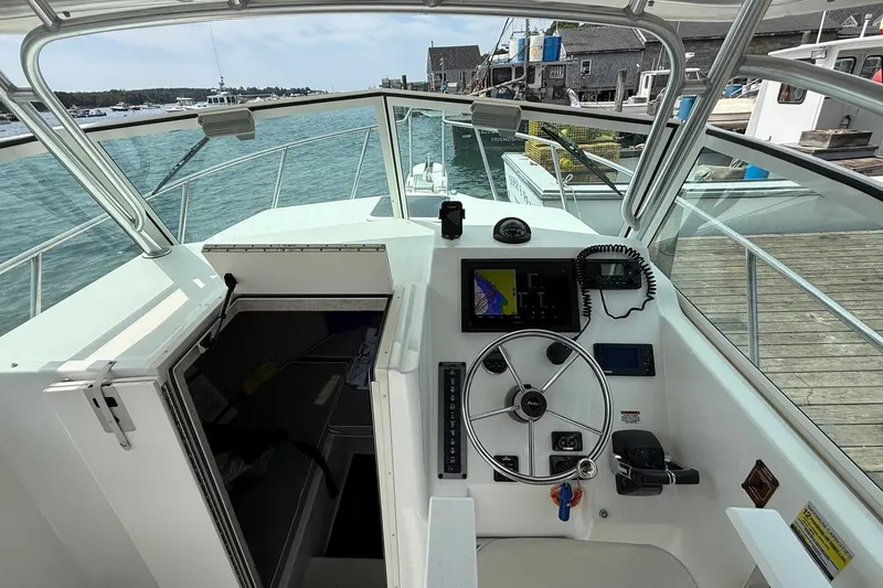 Slide: The Image of 2015 Parker 2510 XLD Walkaround boat cockpit with steering wheel and navigation equipment. - 11