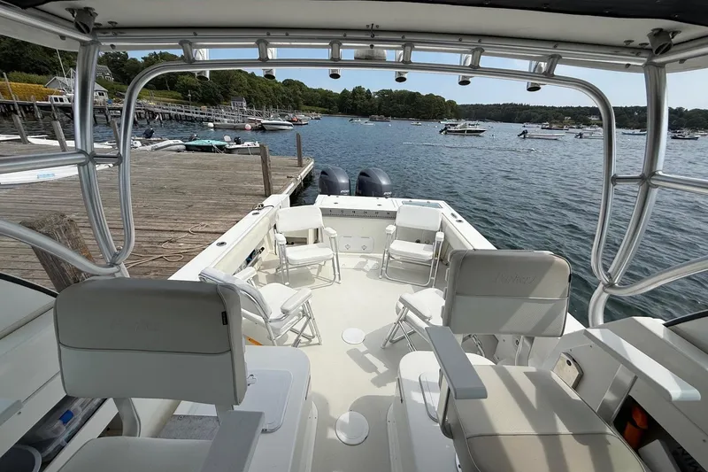 Slide: The Image of 2015 Parker 2510 XLD Walkaround boat docked, featuring spacious seating and scenic waterfront view. - 13