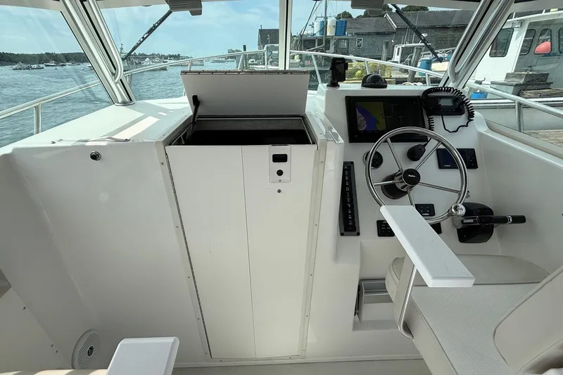 Slide: The Image of 2015 Parker 2510 XLD Walkaround boat cockpit with steering wheel and navigation equipment. - 14