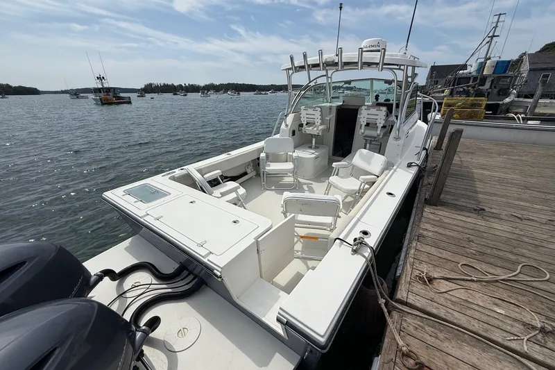 Slide: The Image of 2015 Parker 2510 XLD Walkaround boat docked, featuring spacious seating and dual engines. - 15