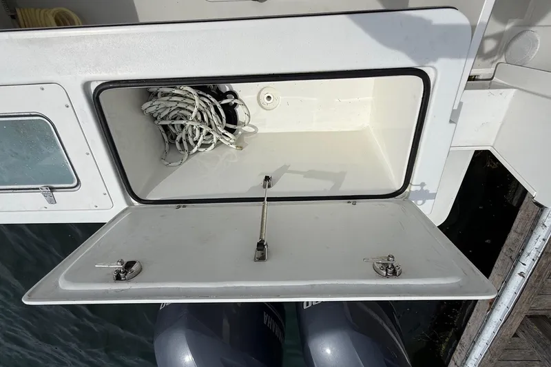 Slide: The Image of Open storage compartment on 2015 Parker 2510 XLD Walkaround boat with coiled rope inside. - 17