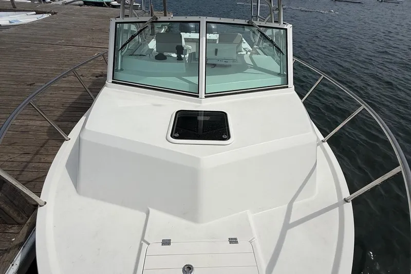 Slide: The Image of 2015 Parker 2510 XLD Walkaround boat docked, showcasing spacious deck and windshield. - 21