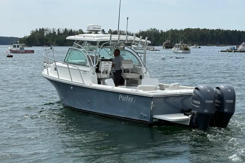 Slide: The Image of 2015 Parker 2510 XLD Walkaround boat with twin Yamaha engines on a calm lake. - 3