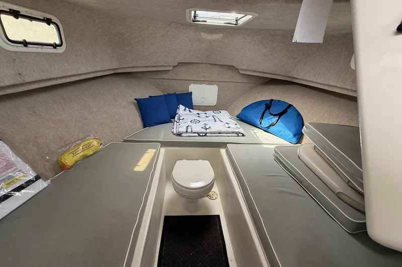 Slide: The Image of 2015 Parker 2510 XLD Walkaround cabin interior with seating, cushions, and a small toilet. - 43