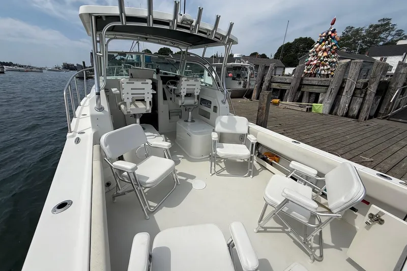 Slide: The Image of 2015 Parker 2510 XLD Walkaround boat with seating, docked near a buoy-decorated pier. - 9
