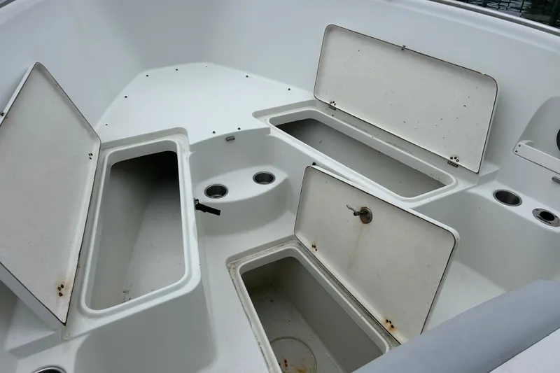 Slide: The Image of 2006 Sailfish 2660 CC boat storage compartments with open lids, showcasing interior space. - 16