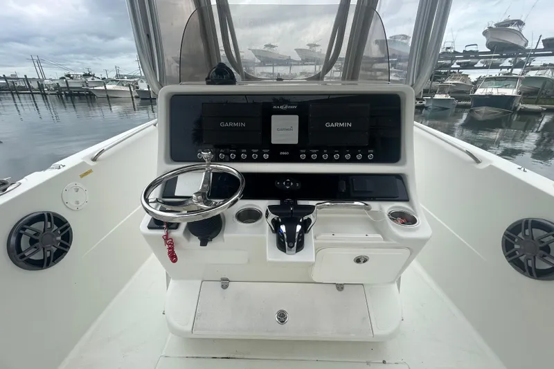 Slide: The Image of 2006 Sailfish 2660 CC boat console with Garmin navigation, docked at marina. - 26
