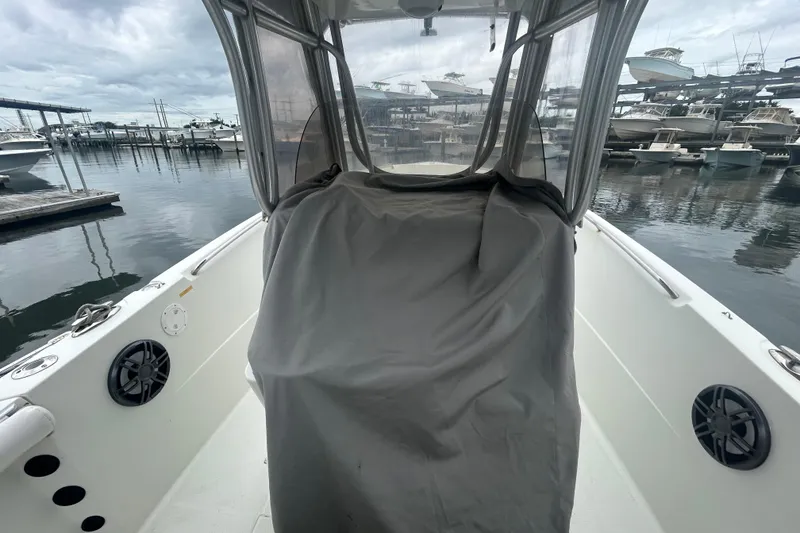 Slide: The Image of 2006 Sailfish 2660 CC boat interior at marina, covered console, overcast sky. - 27