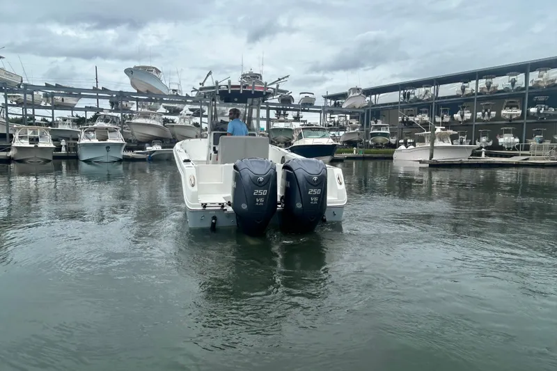 Slide: The Image of 2006 Sailfish 2660 CC boat with dual engines in a marina setting. - 3