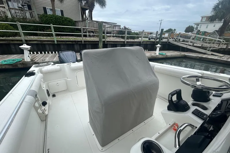 Slide: The Image of 2006 Sailfish 2660 CC boat interior at dock, featuring covered console and steering wheel. - 31