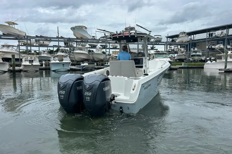 Slide: The Image of 2006 Sailfish 2660 CC boat with twin Yamaha 250 engines in a marina setting. - 6
