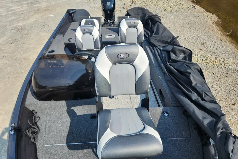 Slide: The Image of 2024 Polar Kraft Frontier 165 SCJ boat interior with seating and console, docked on gravel shore. - 23