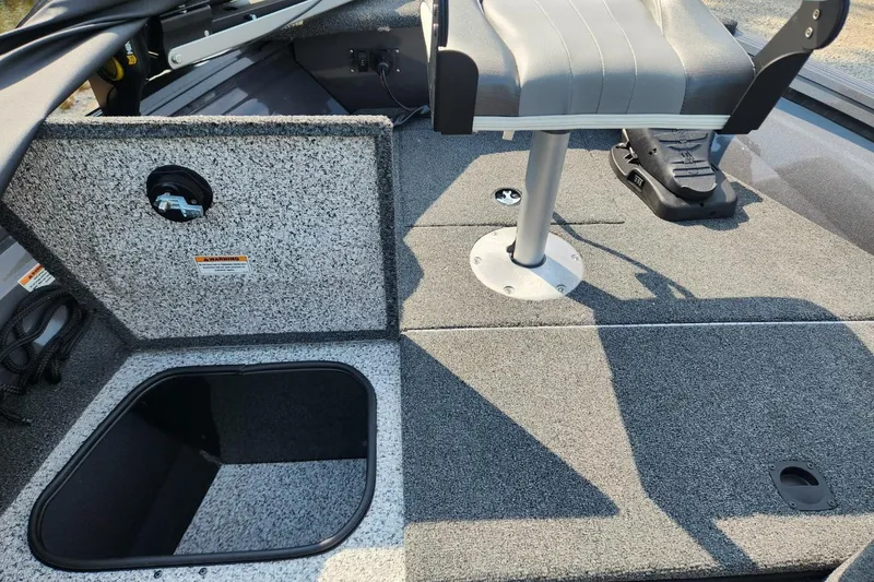 Slide: The Image of 2024 Polar Kraft Frontier 165 SCJ boat interior with storage compartment and seat. - 26