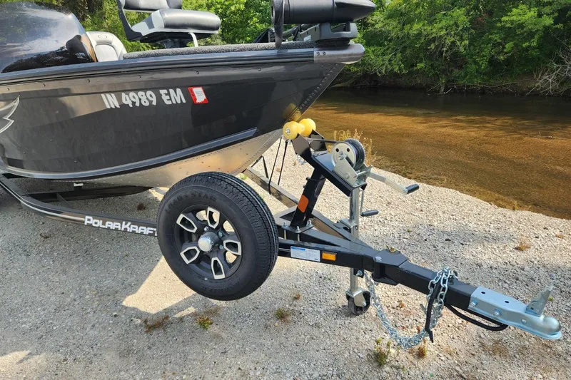 Slide: The Image of 2024 Polar Kraft Frontier 165 SCJ boat on trailer by a riverbank. - 41