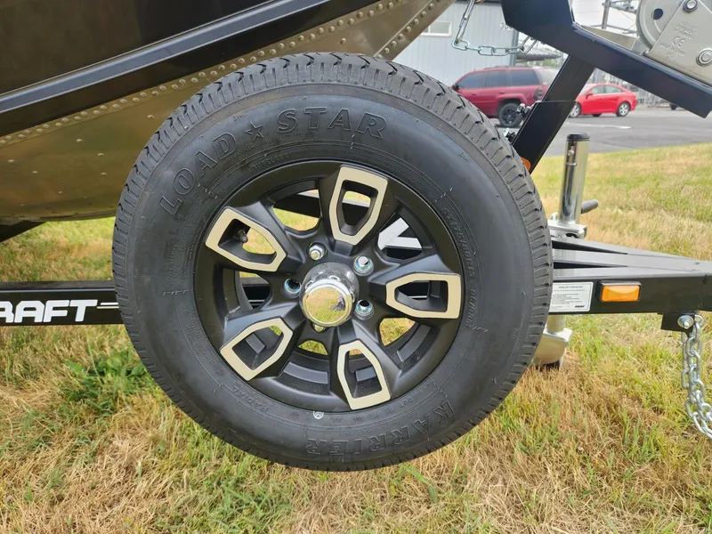 Slide: The Image of 2024 Polar Kraft Frontier 165 SCJ trailer wheel on grass, featuring Load Star tire. - 9