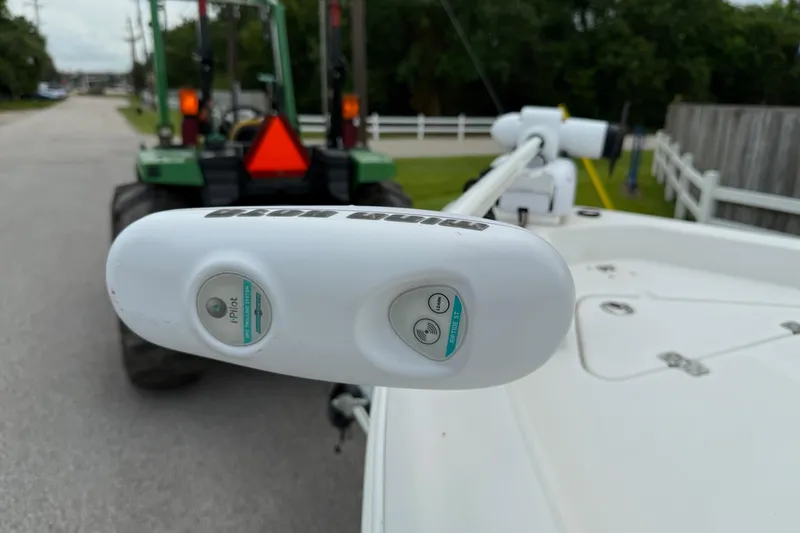 Slide: The Image of 2013 NauticStar 1910 NauticBay boat with i-Pilot trolling motor, parked near a green tractor. - 19