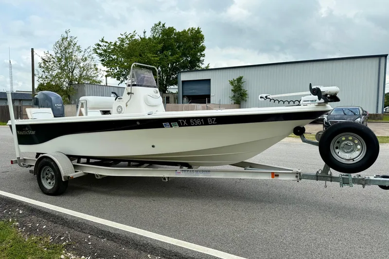 Slide: The Image of 2013 NauticStar 1910 NauticBay boat on trailer, parked outdoors. - 5